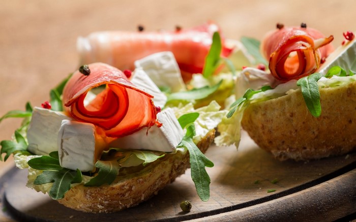 Open-faced sandwiches with ham, cheese, and arugula