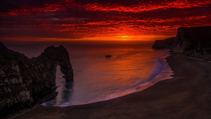 Dramatic sunset over Durdle Door and the Jurassic Coast