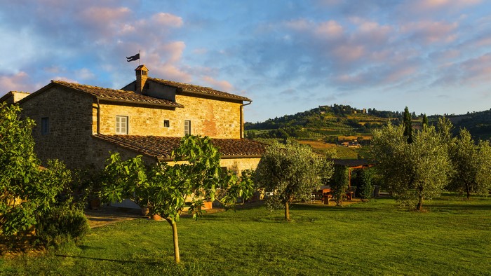 Tuscan farmhouse with olive trees and rolling hills