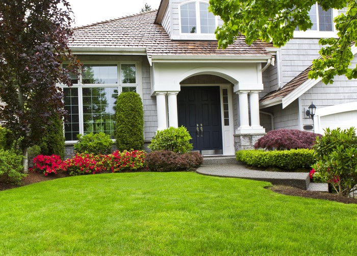 Luxury house with manicured lawn and colorful flowers