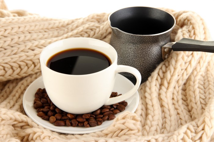 Coffee cup and cezve on a knitted blanket