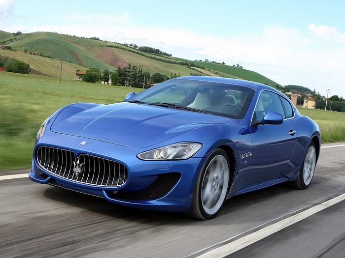 Blue Maserati GranTurismo driving on a road