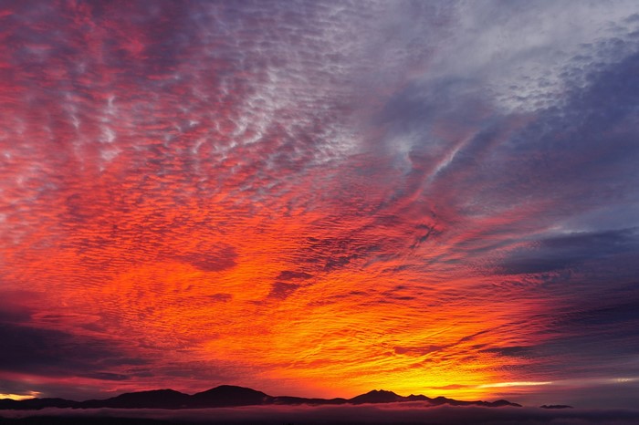 Fiery sunset clouds over mountains