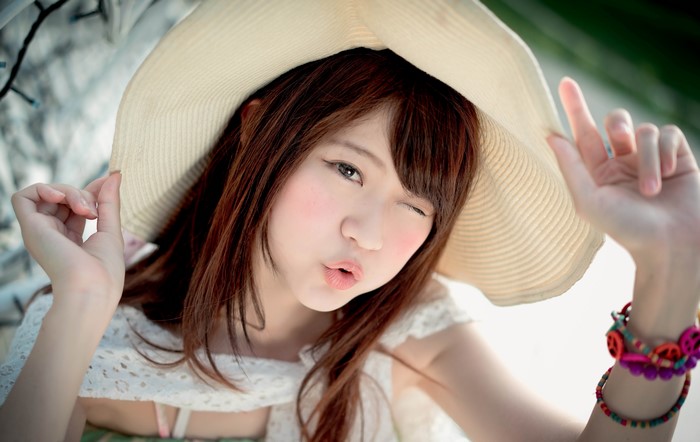 Asian woman with brown hair wearing a hat