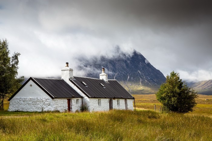 Black Rock Cottage in Scotland with Mountains and Clouds