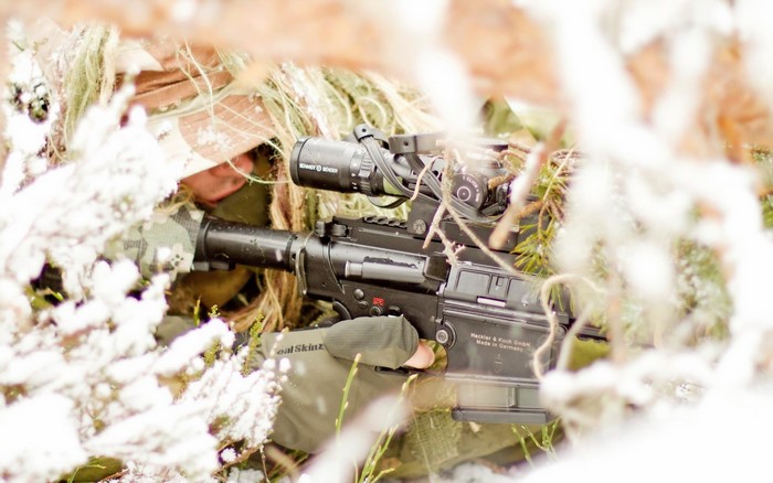Sniper in camouflage with a rifle in winter
