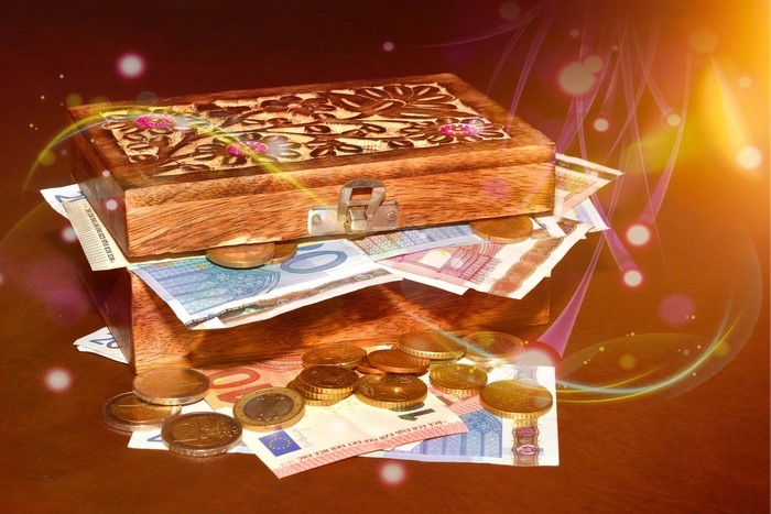 Wooden box with Euro banknotes and coins