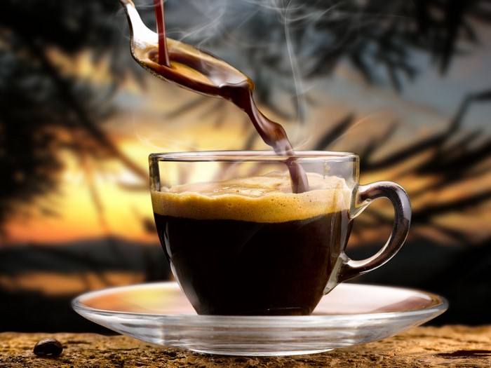 Coffee being poured into a cup with steam