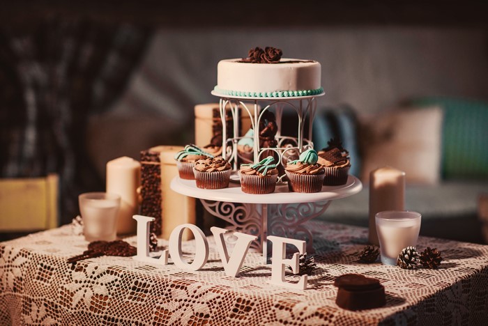 Wedding cake and cupcakes with LOVE letters and candles