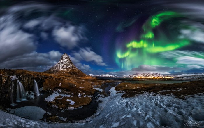 Kirkjufell mountain and waterfall under Aurora Borealis in Iceland