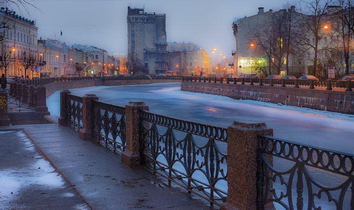 Frozen canal in St. Petersburg, Russia with ornate fence