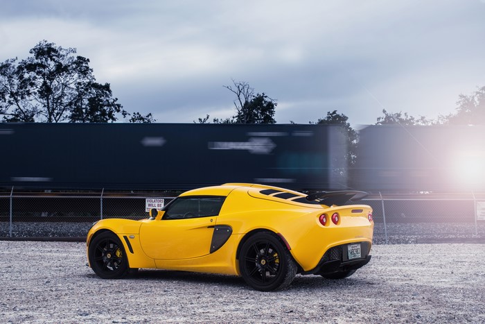 Yellow Lotus Exige car by a train