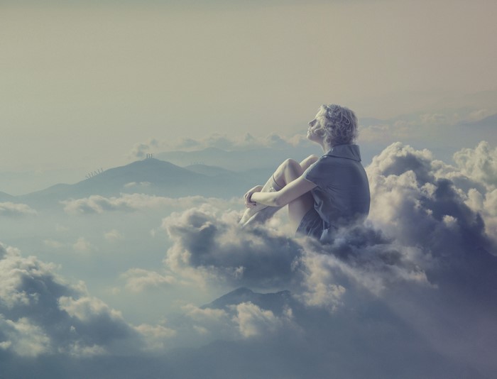 Blonde girl sitting on clouds