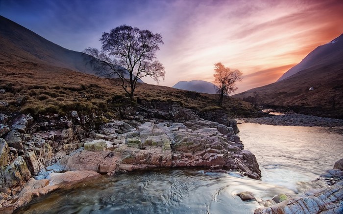 River flowing through a valley at sunset in Scotland