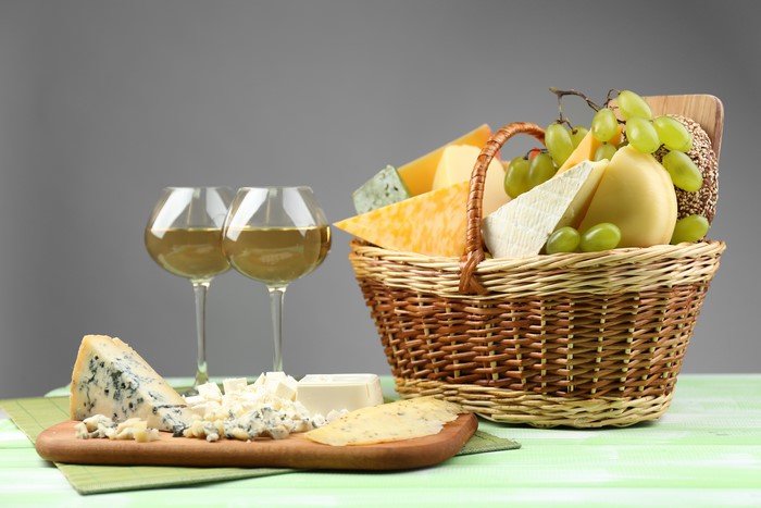 Cheese and wine still life in wicker basket