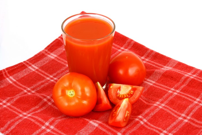 Tomato juice with tomatoes on a red checkered cloth
