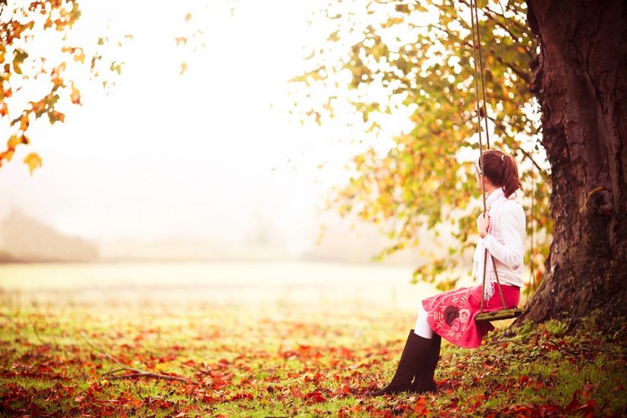 Girl on a swing in autumn park