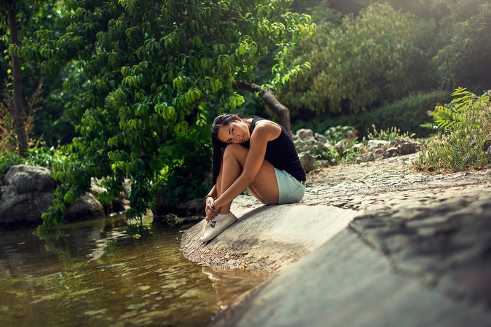 Brunette girl sitting by the water