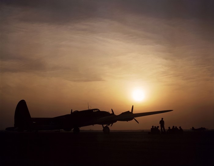 B-17 Flying Fortress silhouetted against sunset