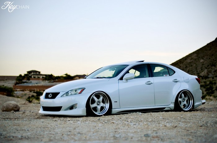 White Lexus IS250 parked on gravel with mountains in background