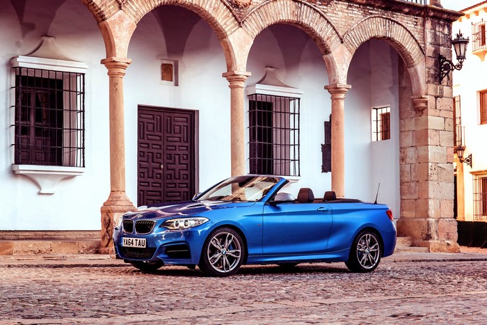 Blue BMW M235i Cabriolet on a cobblestone street