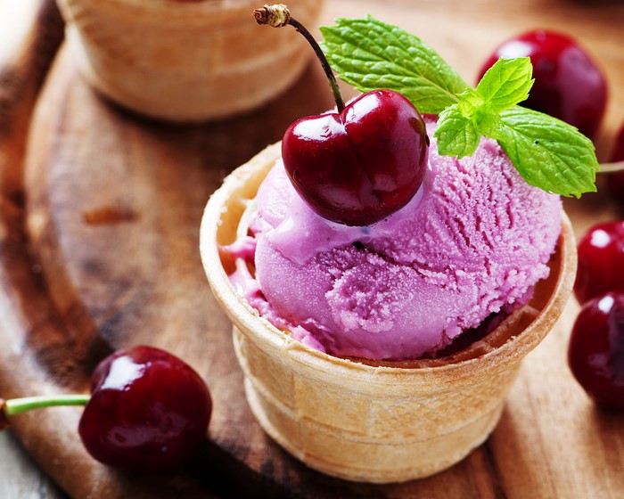 Cherry ice cream in a waffle cone with mint