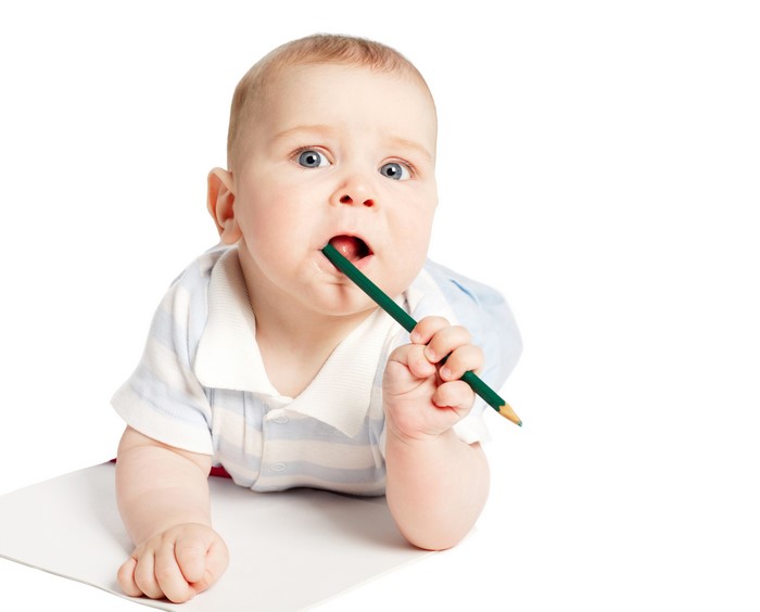 Baby boy with green pencil and paper