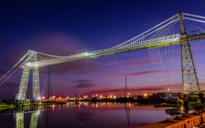 Transporter bridge over river at dusk