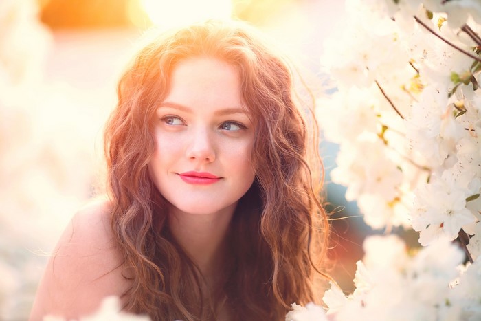Young woman with curly brown hair and blue eyes