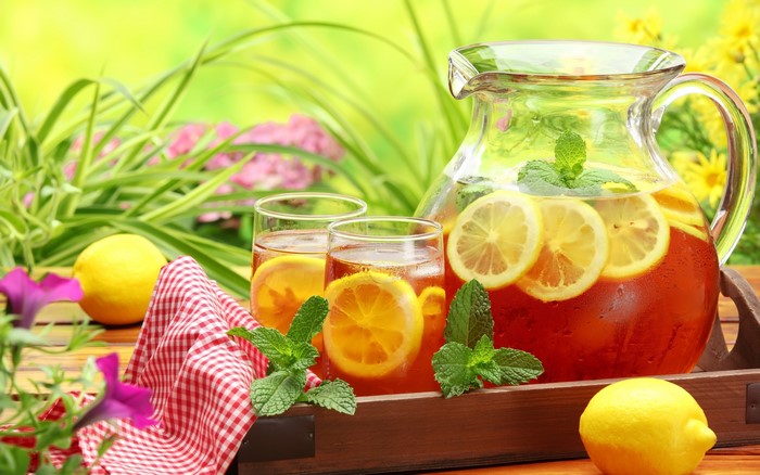 Pitcher and glasses of iced tea with lemons and mint