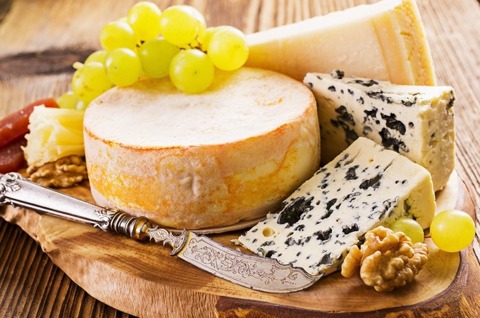 Cheese board with grapes, nuts, and knife