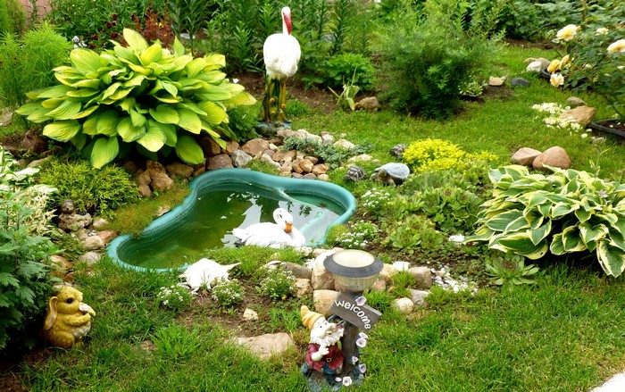 Garden with pond, sculptures, and plants
