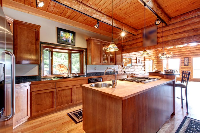 Log cabin kitchen interior with wooden cabinets and island