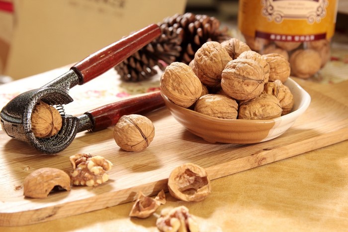 Walnuts and a nutcracker on a wooden board