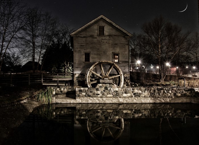 Night scene of a watermill with a large wheel