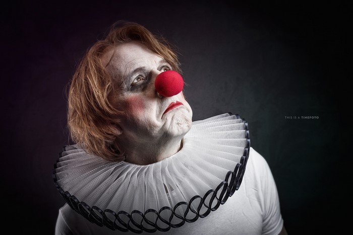 Man in clown makeup with red nose and ruff collar