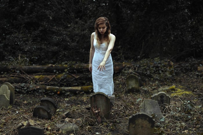 Woman in white dress in a cemetery