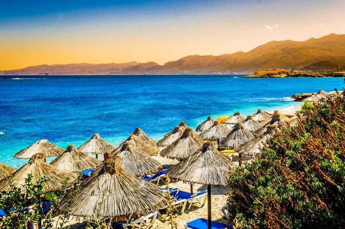 Beach with straw umbrellas and blue sea