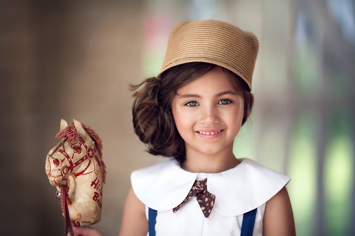 Smiling Girl with Brown Hair Holding Hobby Horse