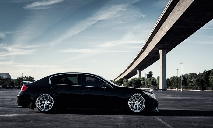 Infiniti G37 sedan parked under a bridge