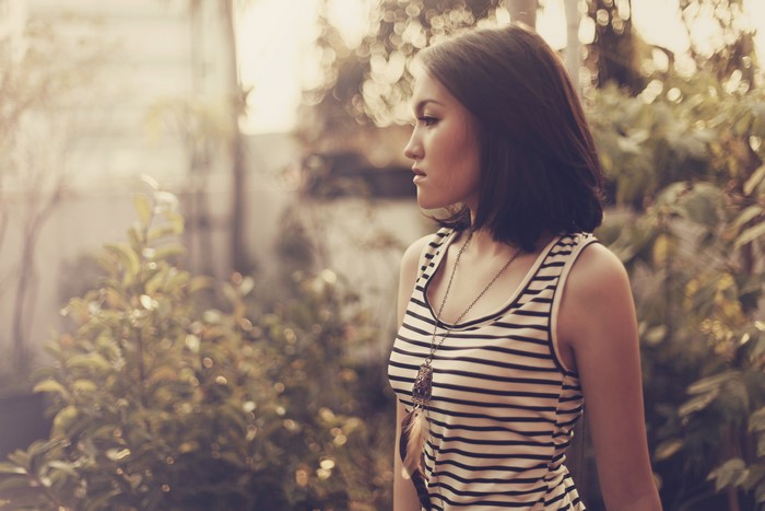 Woman with brown hair wearing a striped singlet