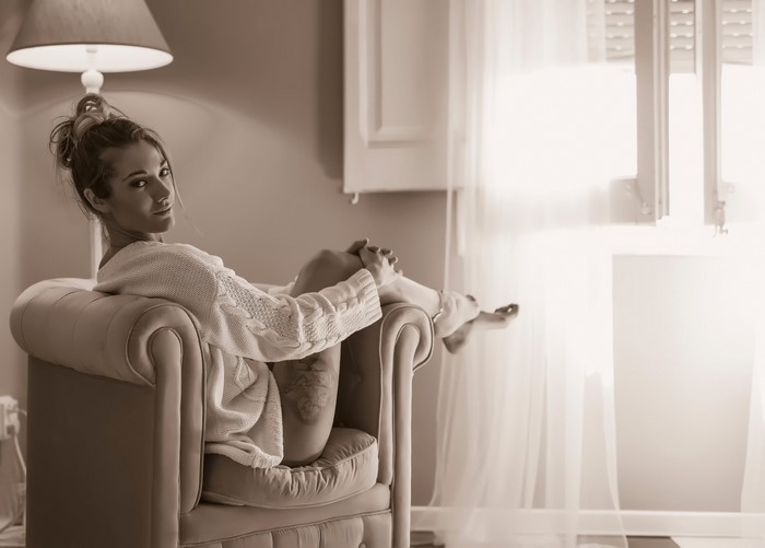 Woman sitting in an armchair wearing a sweater