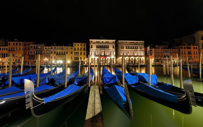 Gondolas docked at night in Venice, Italy