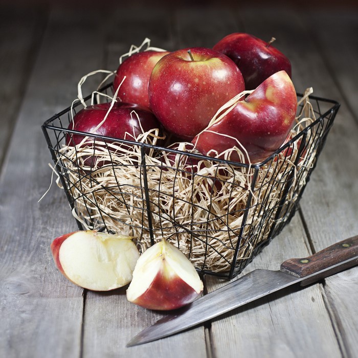 Red apples in a basket with a knife