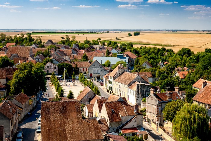 Aerial view of a French village with fields in the background