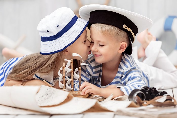 Two children in sailor outfits with toy ship
