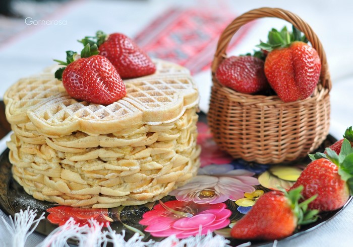 Stack of heart-shaped waffles with strawberries