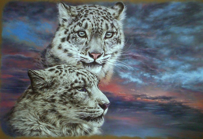 Two snow leopards against a dramatic sky