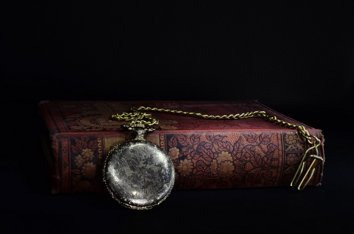 Antique pocket watch on a vintage book
