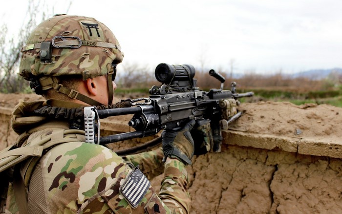 Soldier aiming a machine gun from a trench